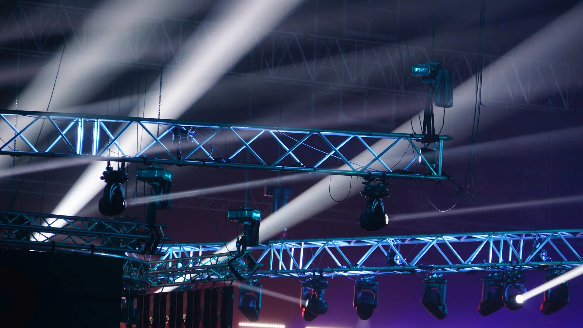 Estructura de truss con luminarias y haces de luz sobre un escenario